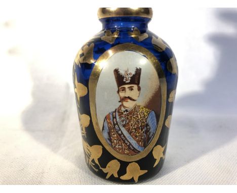 Beykoz - A Turkish Market glass bottle and spire stopper, the cobalt blue ground decorated with reserves containing two portr