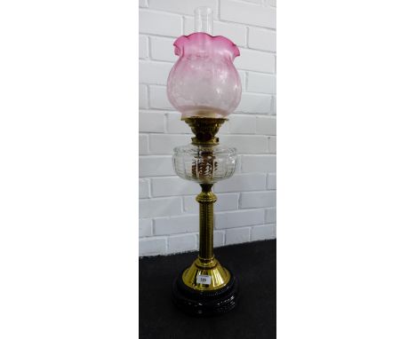Young's brass oil lamp with clear glass well and cranberry coloured etched glass shade 