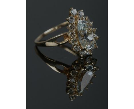 A 10ct gold cluster ring set with pale blue/green stones, with one large pear cut stone under a border of brilliant cut stone