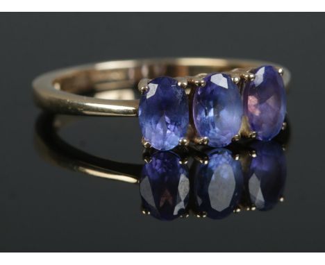 A 9ct Gold three stone Iolite ring. Stamped 375 to the inside of the band. Size O. Total weight: 2.1g.
