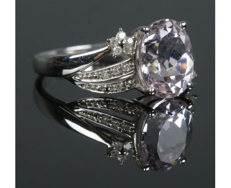 A 9ct White Gold Kunzite and Diamond ring, with large central faceted stone surrounded by Diamond shoulders. Stamped 375 to i