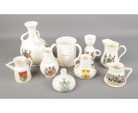 A collection of larger Goss crested ware pieces including triple handled tankard, various jugs and vases