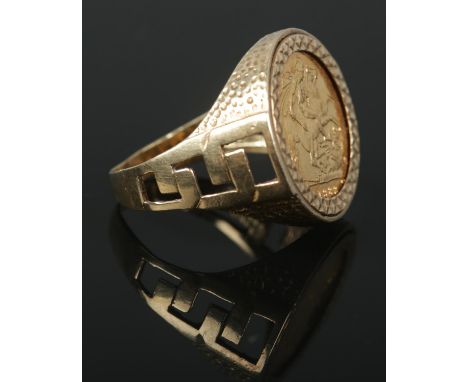 A 9ct Gold mounted half sovereign ring, with pierced shoulders. Size W. Total weight: 9.3g. Stamped 375 to the inside of the 