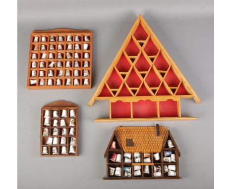 A quantity of ceramic thimbles, mainly souvenir examples in three display stands. With one other empty stand.