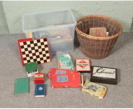 A box and wicker basket containing an assortment of children's toys and books to include Scalextric, Monoply, Cluedo, etc.