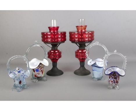 Four Murano glass style baskets together with a matching pair of ruby coloured glass oil lamps