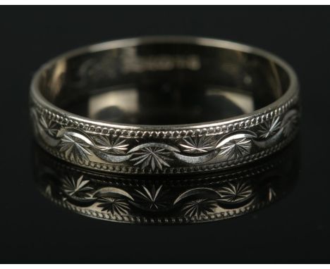 An 18ct white gold ring featuring engraved decoration. Size R, 2.2g.