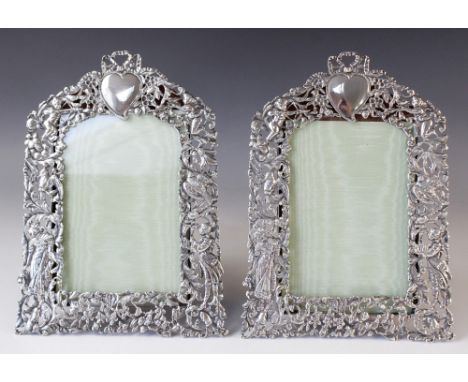 A pair of Victorian silver photograph frames by William Comyns, London 1894, of arched rectangular form with pierced figural,