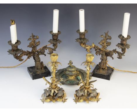 A pair of mid 19th century ormolu candlesticks, cast in the form of leafy stems with three cast silver coloured birds applied