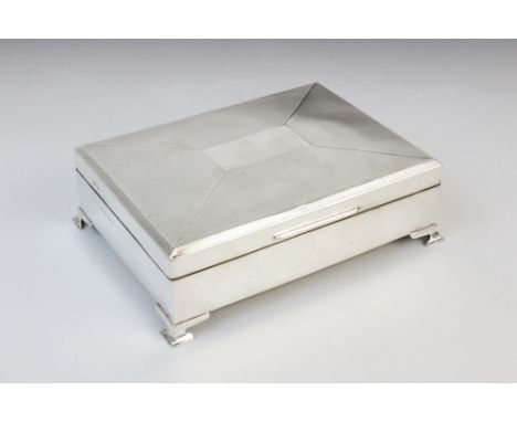 A George V silver cigarette box by W T Toghill &amp; Co, Birmingham 1935, of rectangular form raised on four bracket feet, en