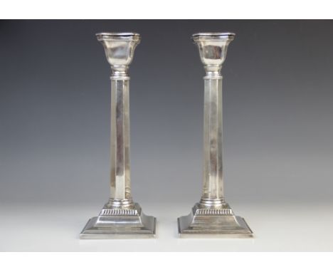 A pair of George V silver candlesticks, marks for 'M.S', London 1933, each with faceted stems and shaped beaded sconces on sq