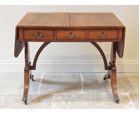 A Regency maple sofa table, in the manner of George Bullock, the rectangular top with rounded drop leaves, over two frieze dr