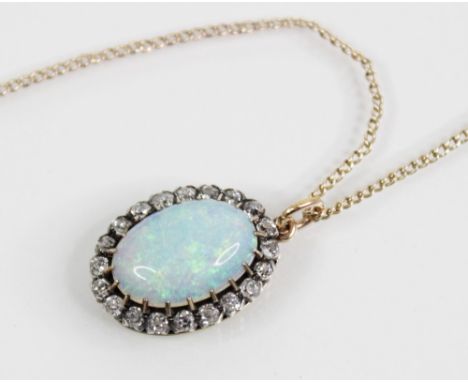 An opal and diamond cluster pendant, the central polished opal cabochon (measuring 14.5mm x 10.1mm x 3.8mm), with a surround 