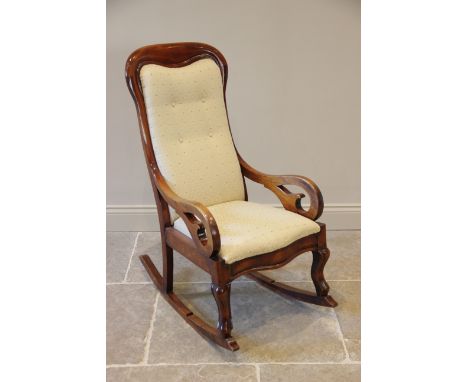 A Victorian mahogany framed rocking chair, the shaped button back within a mahogany frame extending to scrolled arms, enclosi