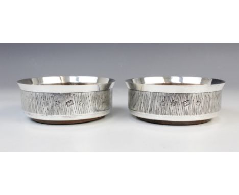 A pair of silver mounted bottle coasters by P H Vogel & Co, Birmingham 1973, each of circular form with bark effect decoratio