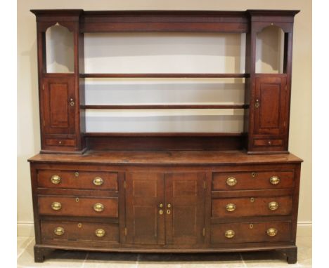 A George III oak and mahogany cross banded dresser,  the inverted breakfront rack with three open shelves flanked by a spice 