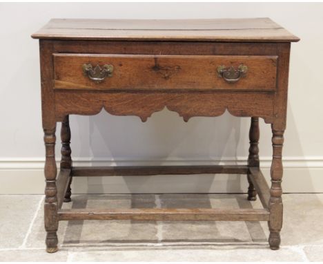 An 18th century oak side table, the rectangular moulded three plank top above a single frieze drawer applied with brass swing