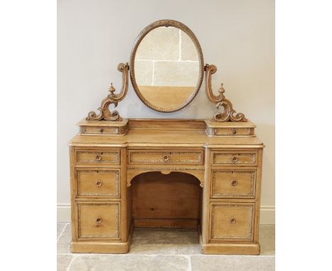 A Victorian pine inverted breakfront kneehole dressing table, the oval swing mirror raised upon 'C' scroll supports and small