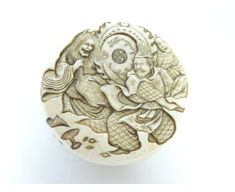 Meiji period carved ivory Manju-Netsuke depicting three figures on one half and the other decorated with tree shedding leaves