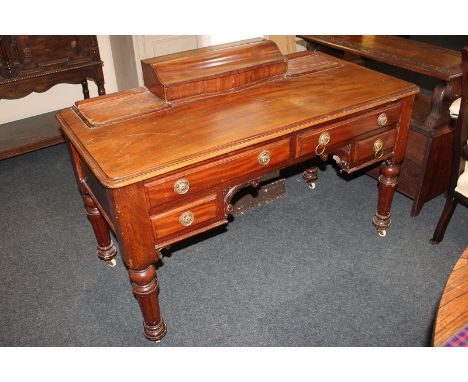 A mahogany desk with central box section above four drawers, and turned legs on ceramic castors, 122cm, (a/f)