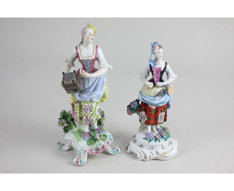 A Sitzendorf porcelain figure of a woman with mask and tool, together with a porcelain figure of a lady with bird cage, ancho