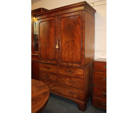 A 19th century mahogany linen press with two panel doors enclosing five sliding drawers, the base with two short over two lon