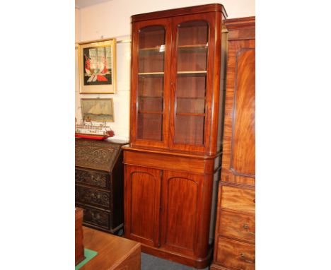 A Victorian mahogany tall bookcase with two glazed panel doors enclosing four adjustable shelves, the lower section with two 