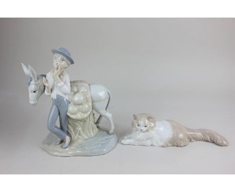 A Nao porcelain model of a cat, together with a Spanish porcelain model of a boy with a donkey, 25cm high