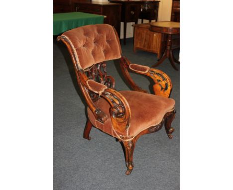 A French upholstered armchair with button back and scroll carved and pierced horizontal back splat, the arms with padded elbo