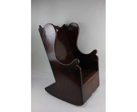 A Georgian mahogany child's commode wing back rocking chair (a/f), 59cm high