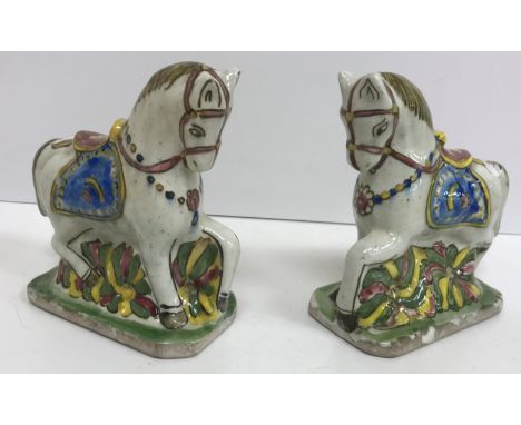 A pair of polychrome glazed faience pottery figures of ceremonial horses with ornate saddles, 18 cm long  x 18 cm high CONDIT