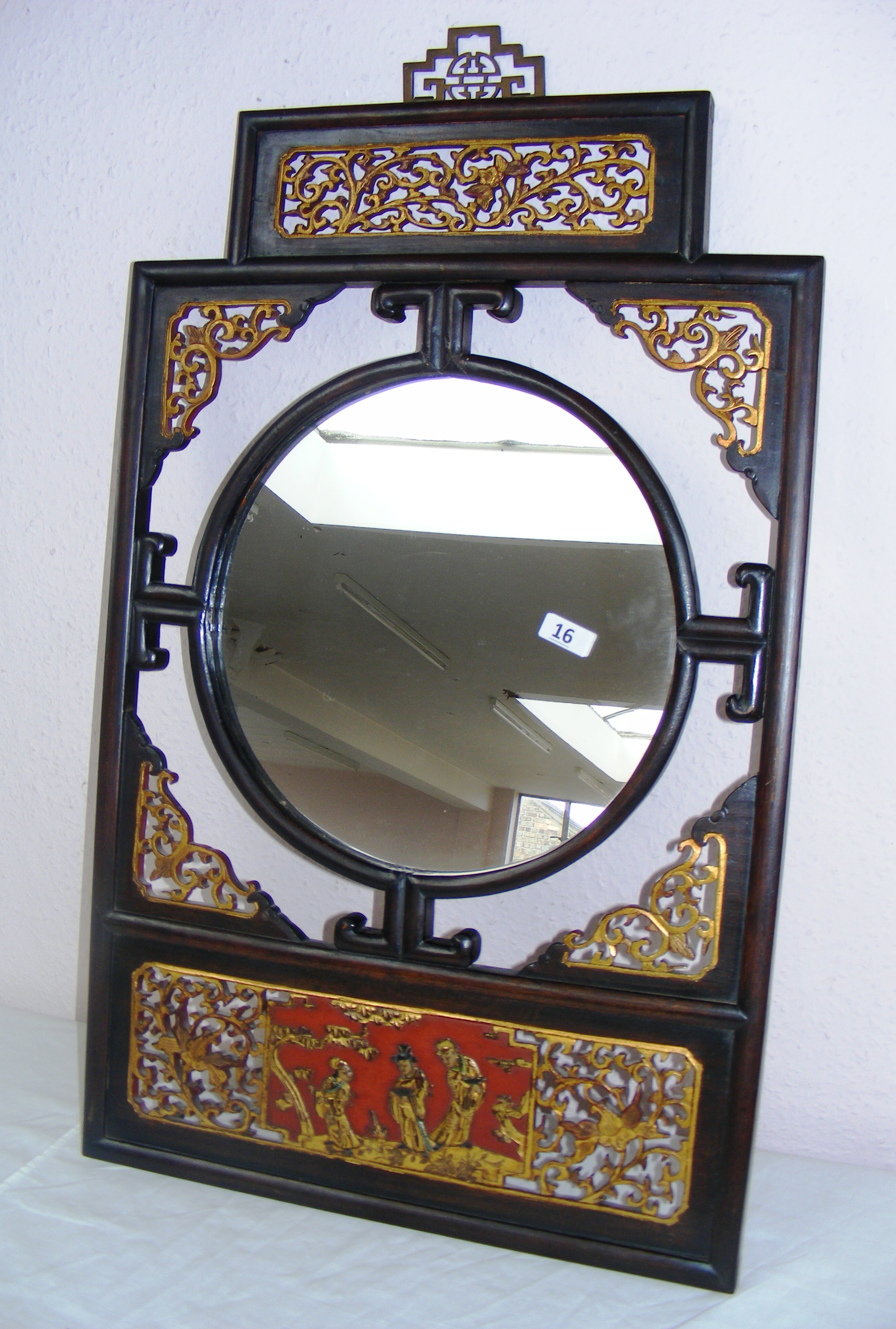 An early 20th century Japanese style mirror with figural carvings and lacquered decoration, in go
