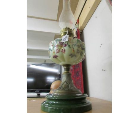 A Victorian oil lamp with hand painted glass font.