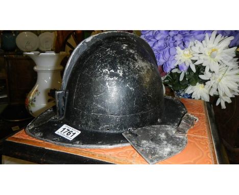An aluminium fire mans helmet and badge.