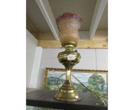 A brass electric table lamp in the form of an oil lamp with shade and chimney.