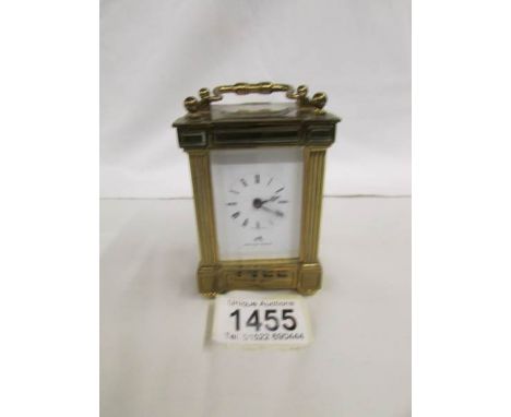 A brass carriage clock by Matthew Norman, 11 jewels, Swiss made with key.