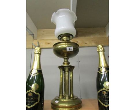 A brass oil lamp on 4 reeded columns with later shade.