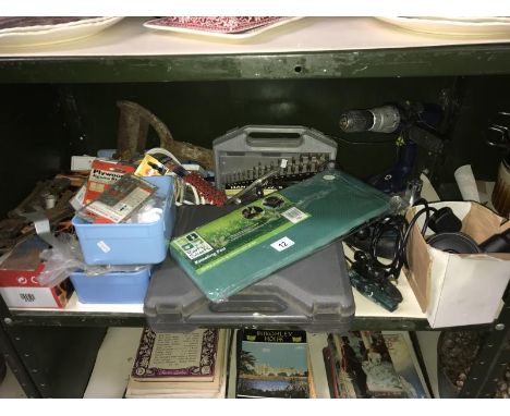 A shelf of DIY tools and fixtures including drill bit set and clips