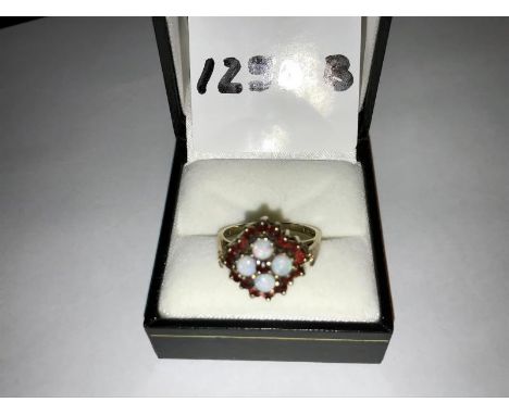 An opal and garnet ring hallmarked 9ct gold 1977, opals ETCW 0.80ct . Ring size R, total weight 4.72g