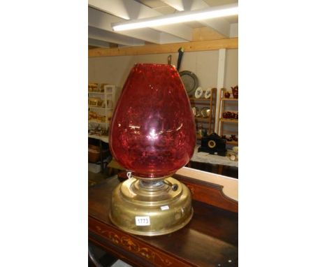 A large brass Sherwood's round wick oil lamp with ruby glass shade.