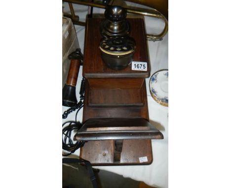 A vintage wall mounting telephone.