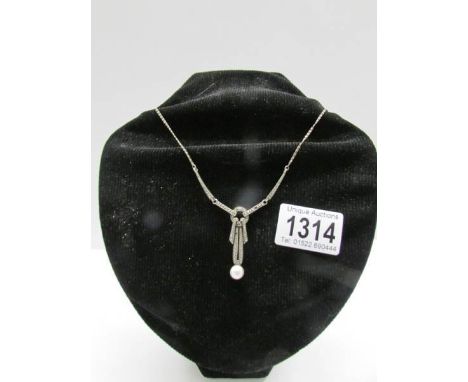 An art deco marcasite necklace set in silver with pearl drop attached.