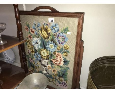 A dark wood stained fire screen with glazed tapestry panel
