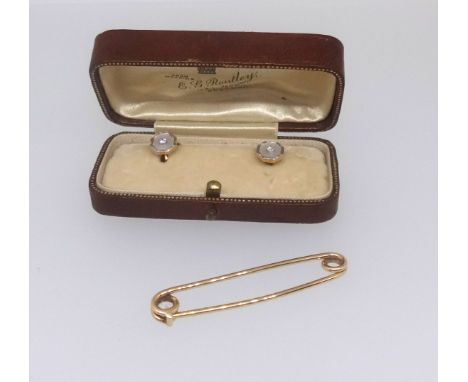 An 18ct bar brooch (3.7gms) together with a pair of 18ct gold dress studs set with a diamond and mother of pearl.
