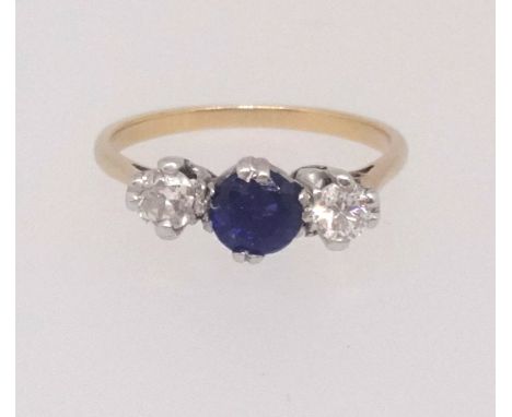 An 18ct sapphire and diamond three stone, finger size K.