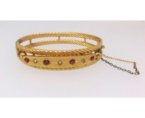 A 9ct diamond and ruby set bangle approx. 13.9gms.
