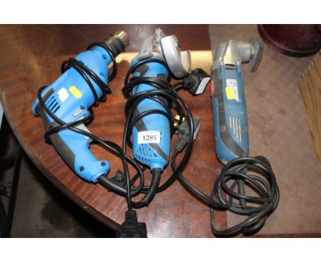 An electric drill together with an angel grinder and orbital sander