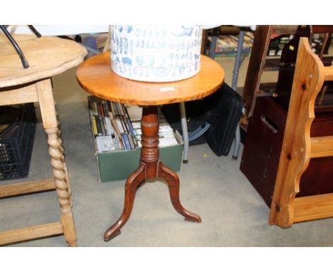 An antique oak snap top table raised on tripod base