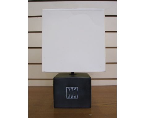 20th century table lamp and white shade, square-shaped, the black base with abstract design, labelled verso 'Designed and Man