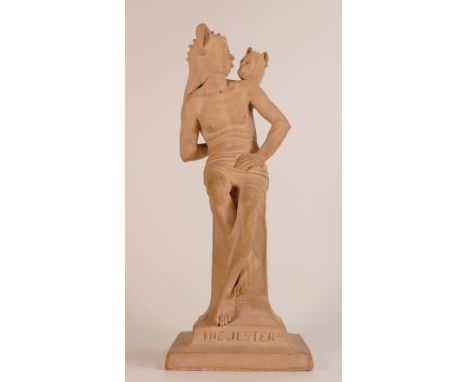 Rare Doulton Lambeth terracotta figure of a Jester seated on a pedestal, looking at a hand held jester puppet. Titled 'The Je